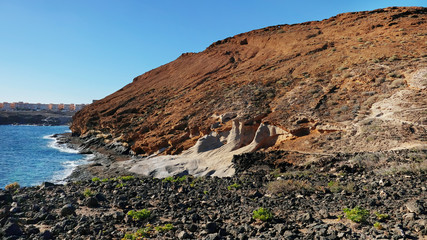 Eroded volcanic cone known as Montana Amarilla, popular hiking attraction with rough badlands, scarce flora and signs of volcanic sediment carved in its rock, in Costa del Silencio, Tenerife, Spain
