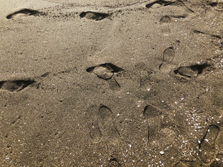Footprints in the sand. Summer sunny day, sandy background