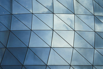 Abstract square and triangle pattern design glass facade wall or window with sky reflection
