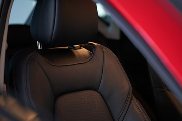 Closeup of a modern car interior with the black leather front seats