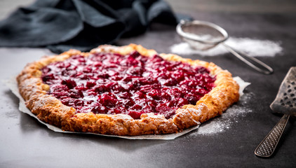 Bakery products. Summer pie with berries. Galeta with cherry sprinkled with powdered sugar.