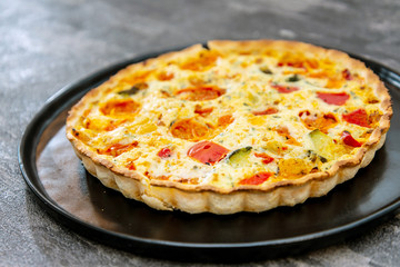 vegetable pie with cherry tomatoes, grilled peppers and courgettes with fresh eggs and fresh cream