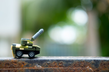 Miniature toys plastic tank on nature background