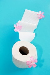 white toilet paper roll with flowers decor on a blue background