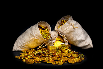 Stacking gold coin in treasure sack on black background
