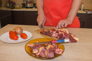 Chef cutting meat on cutting board. Chef at work, kitchen. Preparing meal