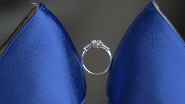 Macro engagement ring in between to blue heels