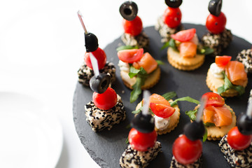 tasty and delicious catering stands on stone trays and on white wooden tables