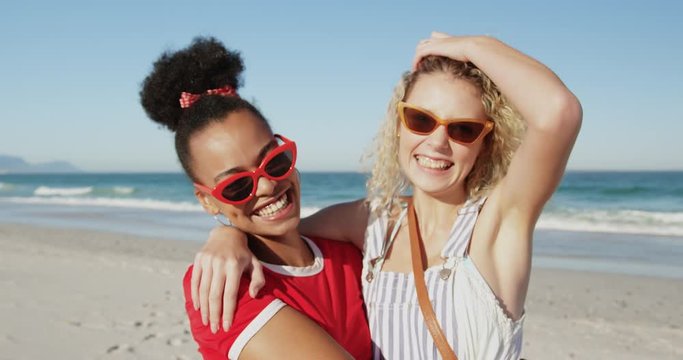 Two young adult female friends having fun at the beach 4k