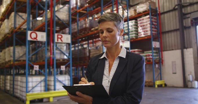 Portrait of female manager smiling to camera in a warehouse 4k