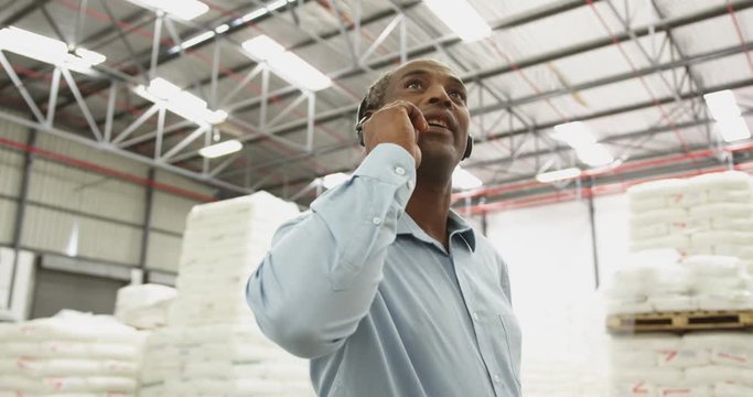 Close up of a male warehouse worker using headset in a storeroom 4k