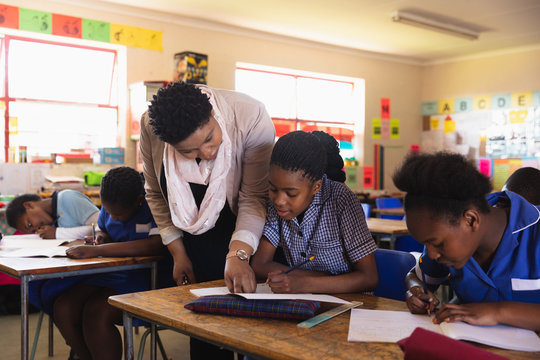 Teacher helping schoolchildren in a lesson at a township school