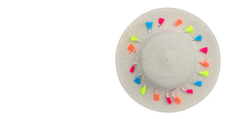 Beautiful straw hat with ribbon and multi colored pompons isolated on white background. Beach hat from a top view