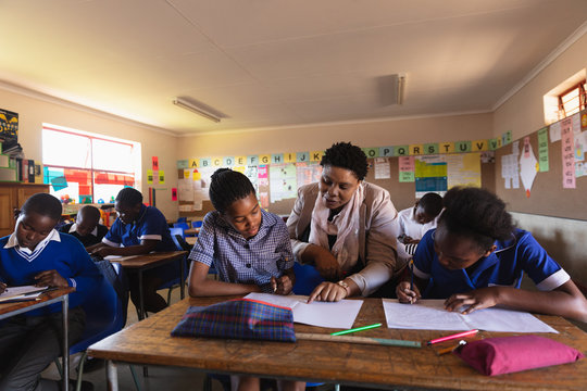 Teacher helping schoolchildren in a lesson at a township school