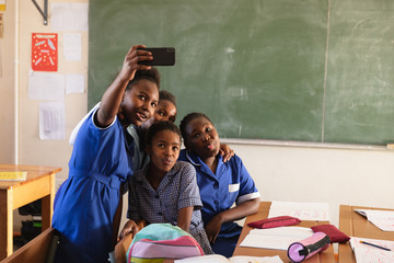 Schoolchildren taking selfies during a break at a township school