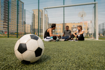 Soccer ball lying on the field or playground on background of players