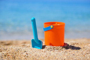 Fototapeta na wymiar Bright plastic сhildren's beach toys on sand near sea. Summer vacation concept