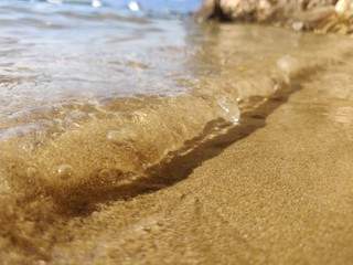 Fototapeta na wymiar Wave in focus on a sand beach