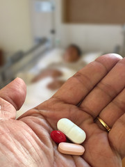 pills and medicines in male  hand for patient in the hospital room,healthcare concept or Treatment and pharmacy concept