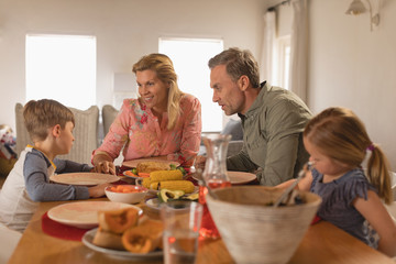 Family interacting with each other while having food on dining table