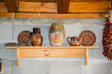 Traditional old bulgarian objects - dried pepper, corn, clay pots, colourful rug, plate and...