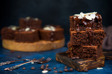 Traditional Belgian chocolate brownies decorated with warm chocolate lie on a wooden Board....