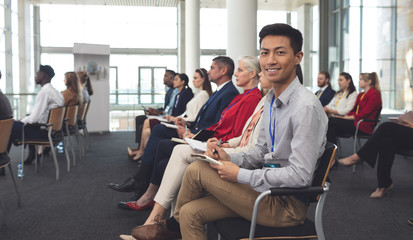 Happy businessman looking at camera in a seminar