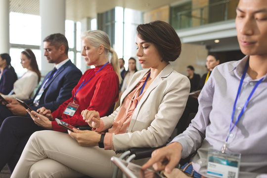 Business people using digital tablet during business seminar