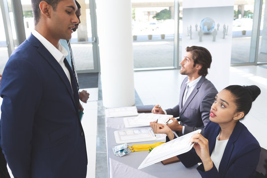 Business people checking in at conference registration table