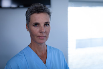 Female matured surgeon standing in clinic at hospital