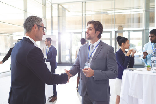 Business people shaking hand during a seminar - Powered by Adobe