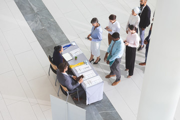 High angle view of business people checking in at conference registration table