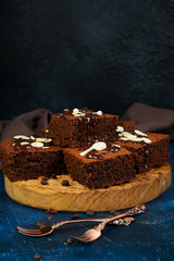 Traditional Belgian chocolate brownies decorated with warm chocolate lie on a wooden Board. Horizontalna orientation.