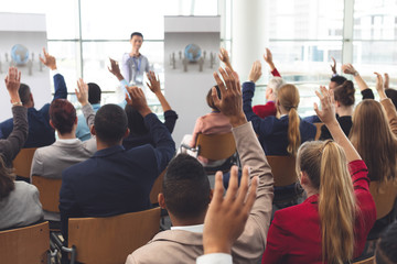 Business people raising their hands at a business seminar