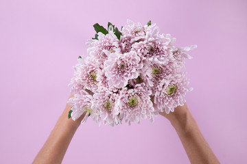 Woman holding a pink bouquet of flower between her hands