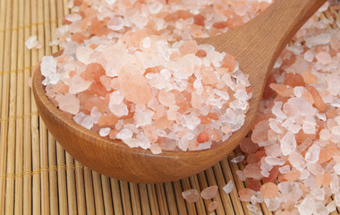 Himalayan rock salt with wooden spoon on bamboo background