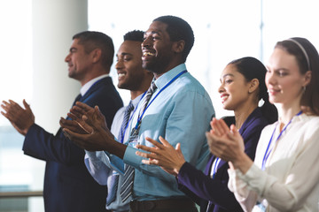 Happy business people applauding in a business seminar