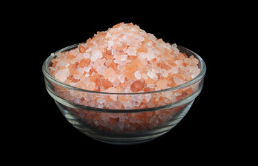 Pink himalayan rock salt in bowl isolated on black background