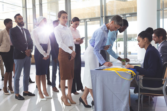 Businesswoman and businessman signing in at conference registration table