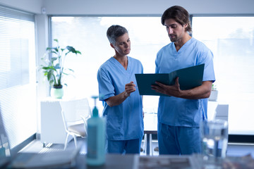 Surgeons discussing over medical file in clinic at hospital