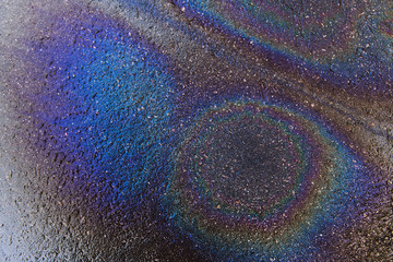Fototapeta premium Iridescent gasoline spot on a wet pavement. Environment pollution background. Ecological disaster abstract.