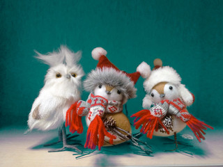 Christmas card. Birds, toy owl in fur hats and knitted scarves, Christmas decoration