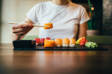 Obraz na płótnie Canvas Young woman eating sushi
