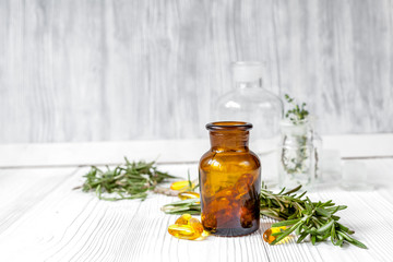 concept - natural medicine herbs in bottles on wooden background