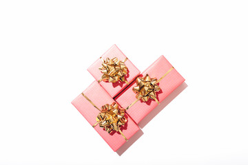 Three pink gift boxes with shiny golden bows