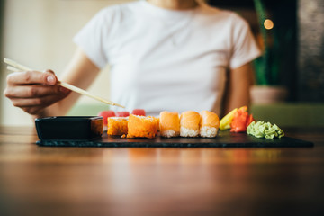 Woman's hand holding chopsticks over plate