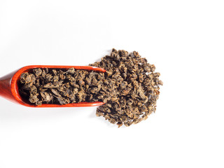 Fermented granular tea from Cherry (Cerasus) leaves in horizontal wooden scoop on white background