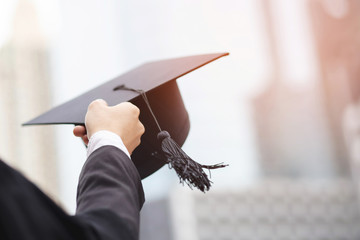 close up people show hand hold show hat in background School building. Shot of graduation cap...