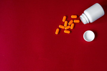 orange tablets in plastic container top view