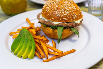A hunberger with fried potatos and abocado, Mexico